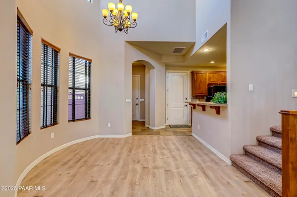a view of a room with a chandelier and wooden floor