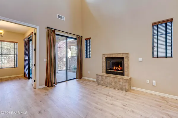 an empty room with wooden floor and fireplace