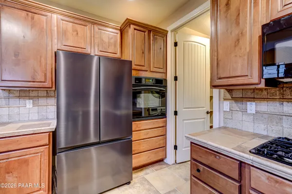 a kitchen with stainless steel appliances granite countertop a refrigerator and a refrigerator