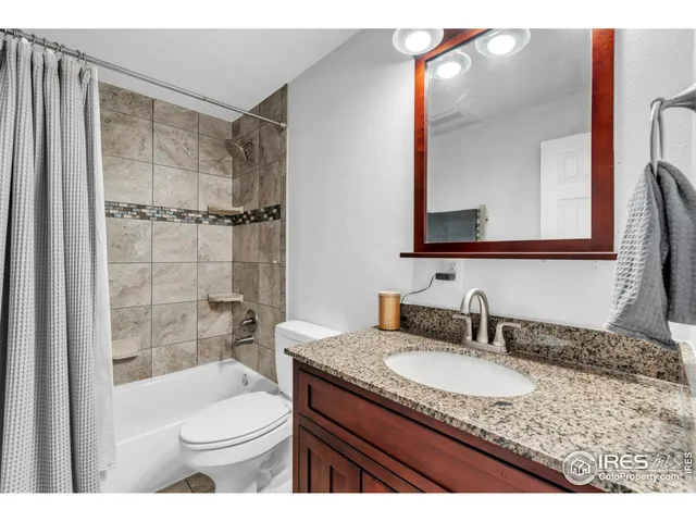 a bathroom with a granite countertop sink toilet mirror and shower