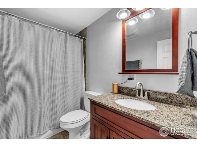 a bathroom with a granite countertop sink toilet and a mirror