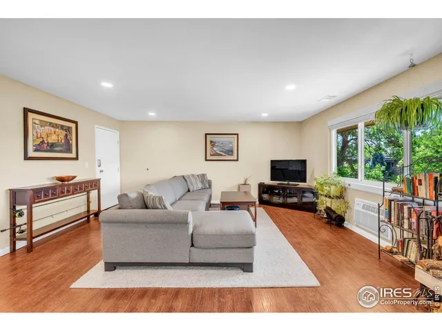 a living room with furniture flat screen tv and a large window