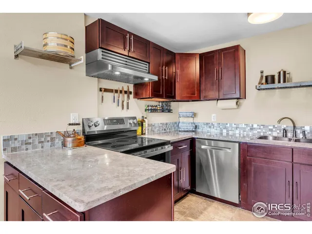 a kitchen with granite countertop a sink a stove and cabinets