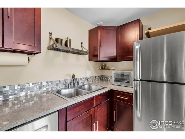 a kitchen with a sink a refrigerator and cabinets