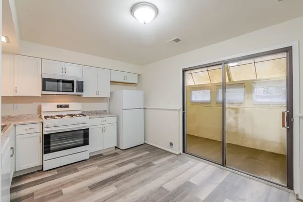 a kitchen with white cabinets and white appliances