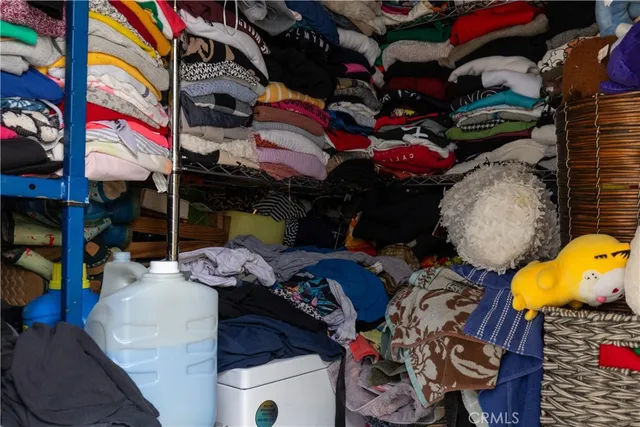 a view of walk in closet with clothes and shoes
