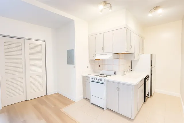 a view of a room with wooden floor and a bathroom