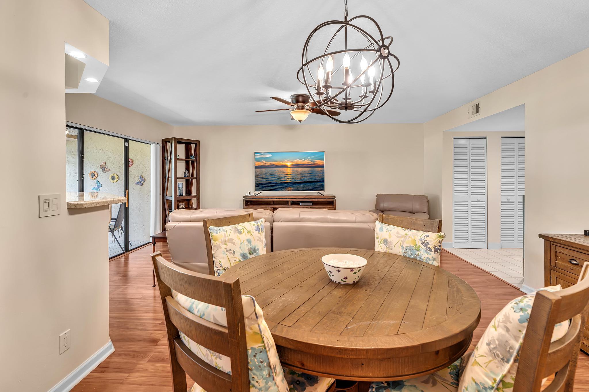 17372 Boca Club Boulevard, Unit 405 Boca Raton, FL 33487 - Photo 35 of 74 a dining room with wooden floor a chandelier a wooden table and chairs