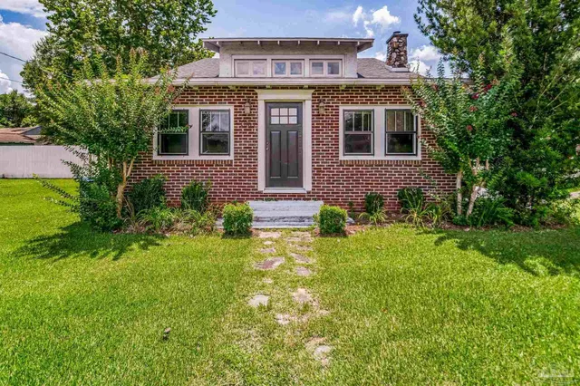 a view of a house with a big yard and potted plants