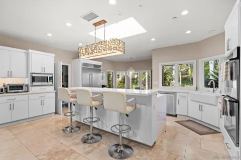 a dining room with wooden floor and chandelier