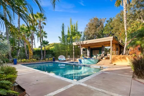 a view of a house with swimming pool and sitting area