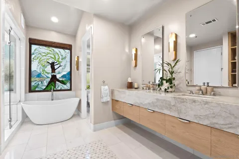 a bathroom with a granite countertop sink and a bathtub