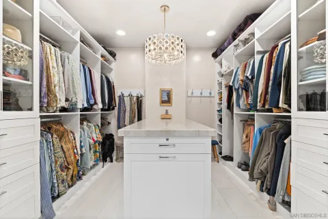 a view of walk in closet with clothes and shoes