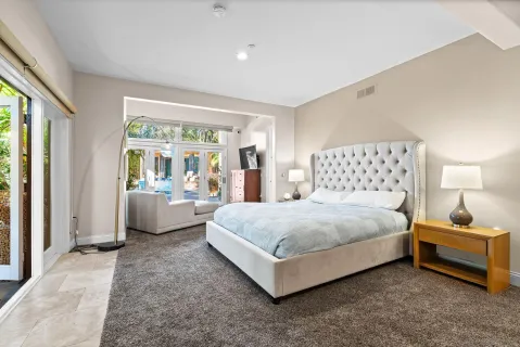 a bedroom with bed and a large window