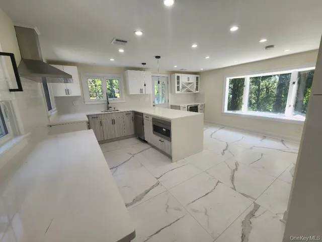 a large white kitchen with a large window