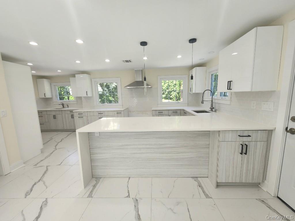 20 North Ravine Road Kings Point, NY 11023 - Photo 13 of 49 a large white kitchen with kitchen island a sink a stove a refrigerator and white cabinets