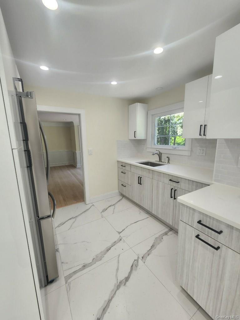 20 North Ravine Road Kings Point, NY 11023 - Photo 15 of 49 a kitchen with stainless steel appliances a sink stove and cabinets