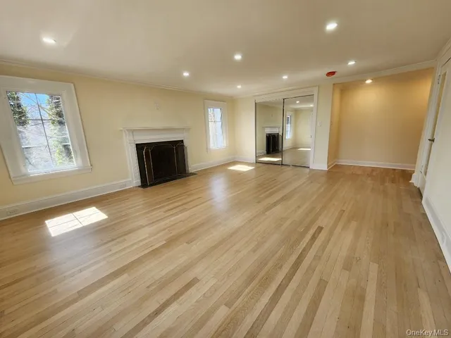 a view of empty room with wooden floor and fireplace