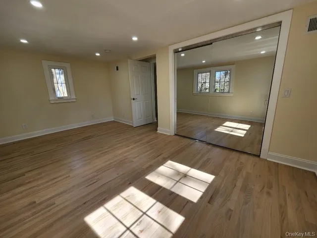 a view of wooden floor and windows in the room