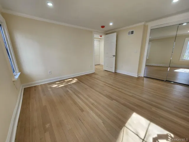 wooden floor in an empty room with a window