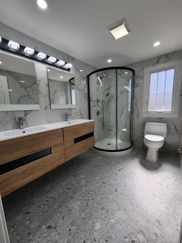 a bathroom with a sink a toilet and mirror