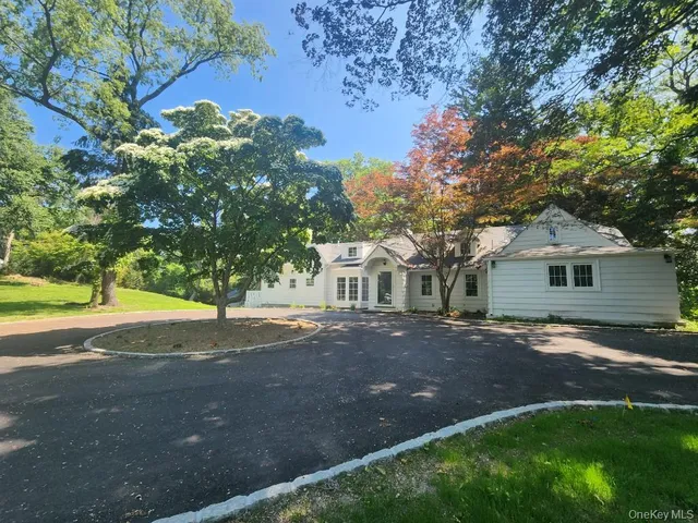 a front view of a house with a garden and tree