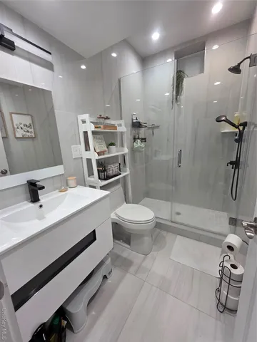 a bathroom with a sink a toilet a mirror and shower