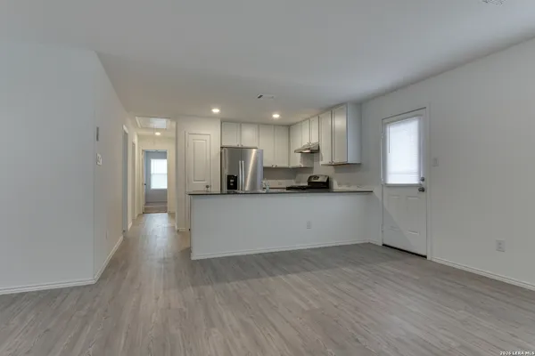 a view of kitchen with wooden floor and electronic appliances