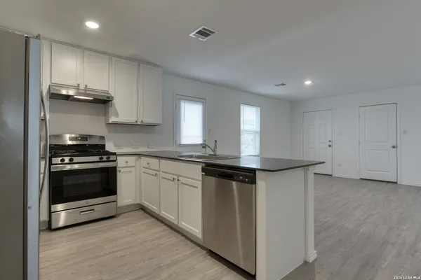 a kitchen with stainless steel appliances granite countertop a stove and a sink
