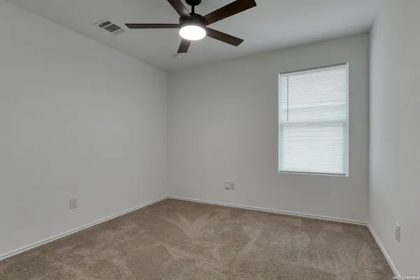 an empty room with a window and a fan