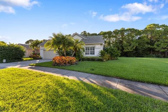a front view of a house with a yard and trees