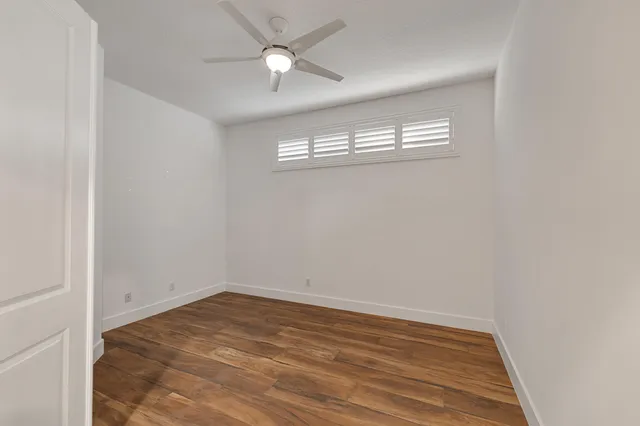 a view of a room with wooden floor and a window