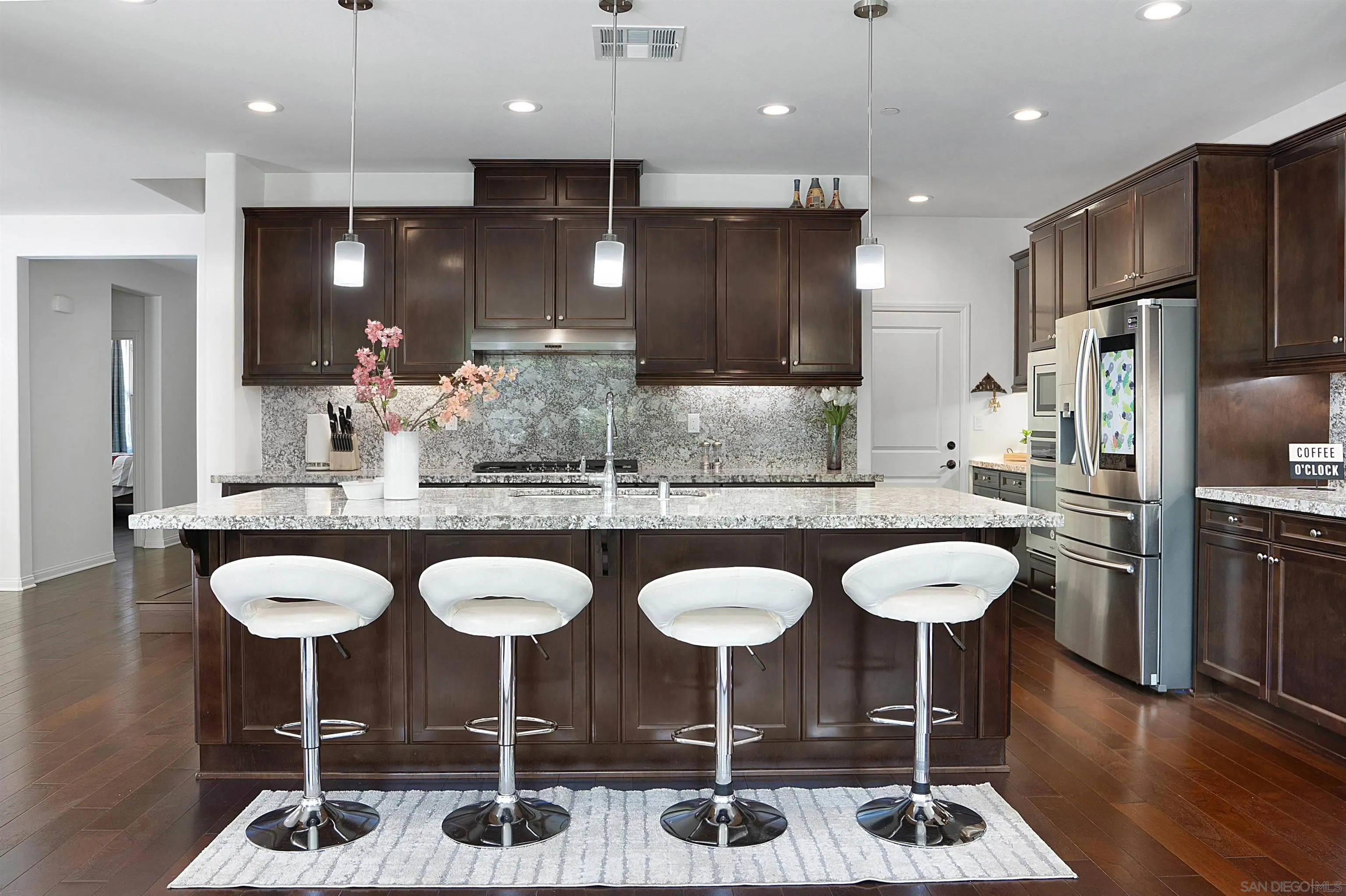 15901 Sarah Ridge Road San Diego, CA 92127 - Photo 8 of 34 a kitchen with stainless steel appliances kitchen island granite countertop a sink and chairs