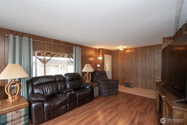 a living room with furniture a flat screen tv and a large window