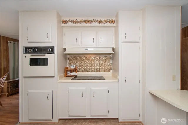 a white kitchen with granite countertop white cabinets and white appliances