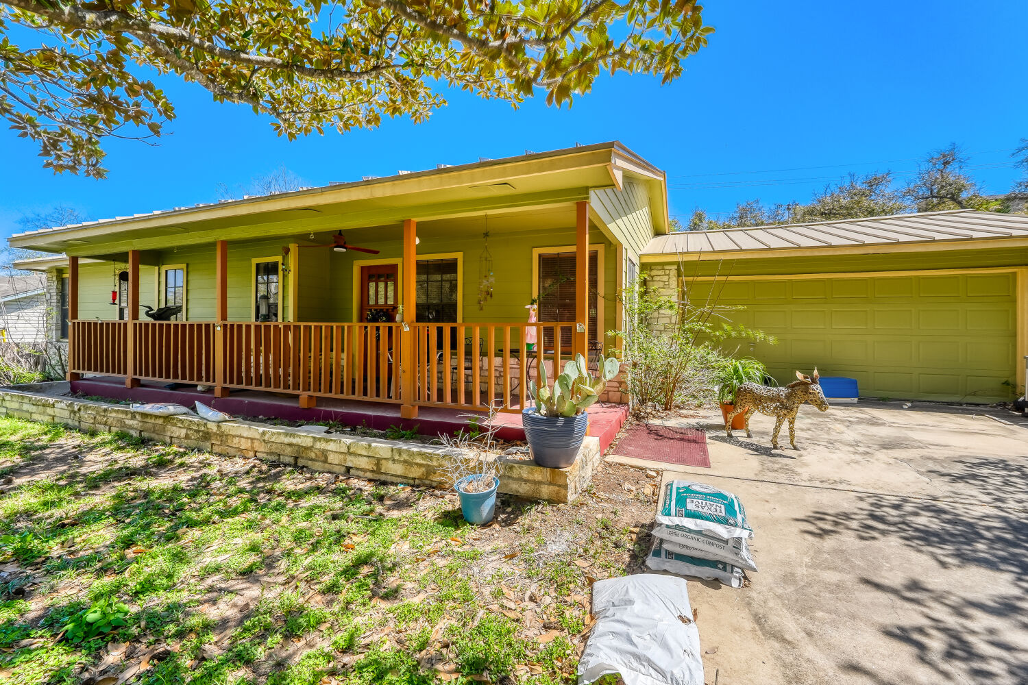 6901 Raccoon Run Austin, TX 78736 - Photo 1 of 1 View of front facade with a porch, an attached garage, concrete driveway, and a ceiling fan