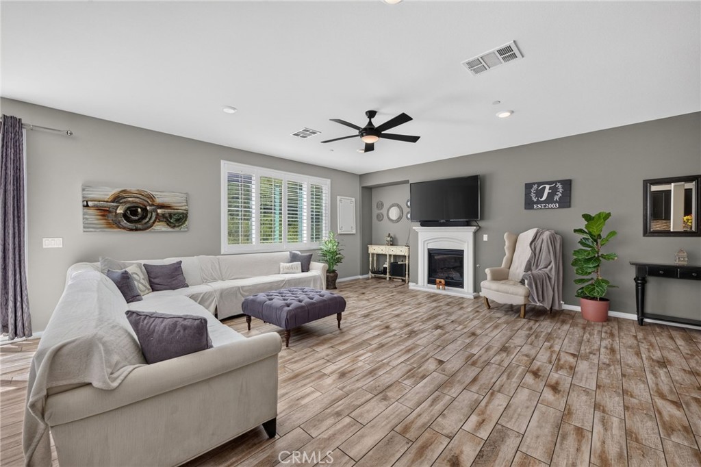 23347 Crystal Way Wildomar, CA 92595 - Photo 15 of 109 a living room with furniture a fireplace and a flat screen tv