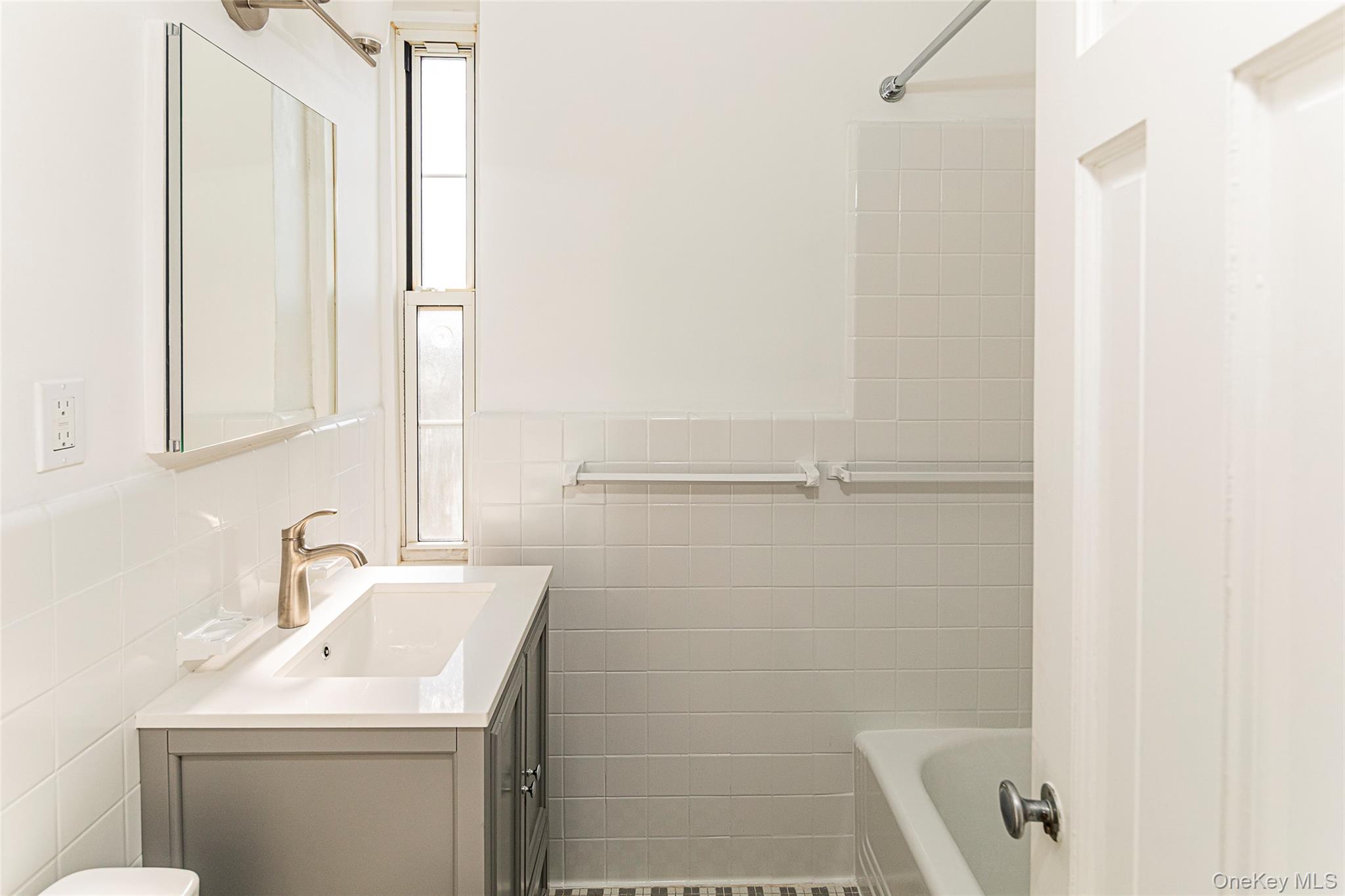 6 Midland Gardens, Unit 4B Bronxville, NY 10708 - Photo 11 of 16 a bathroom with a sink a vanity and a mirror
