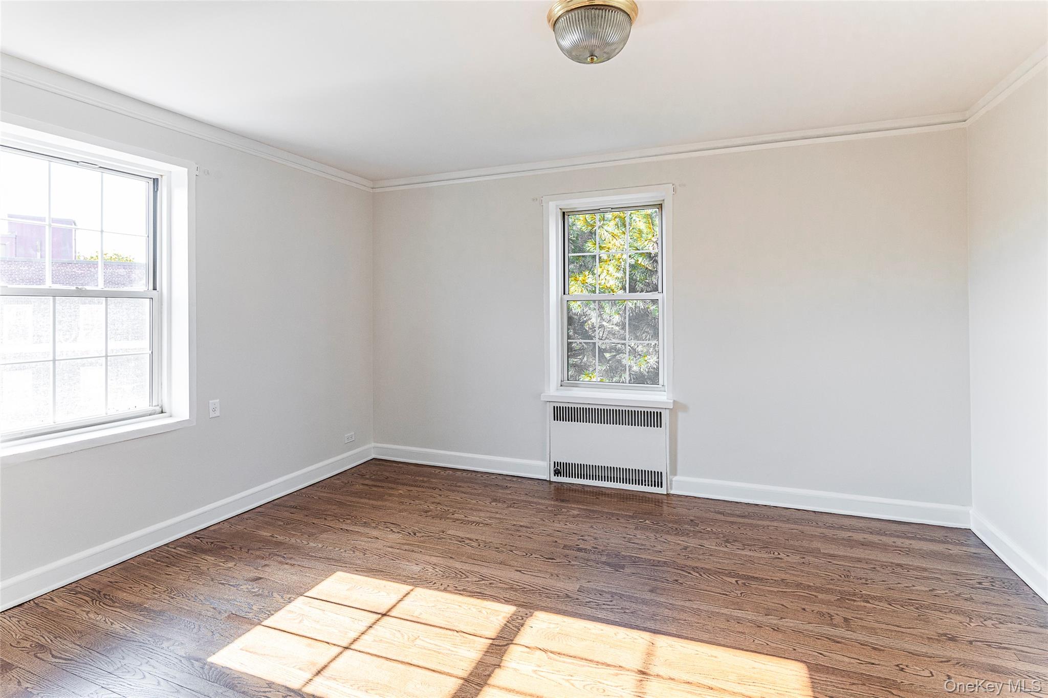 6 Midland Gardens, Unit 4B Bronxville, NY 10708 - Photo 9 of 16 an empty room with wooden floor and windows