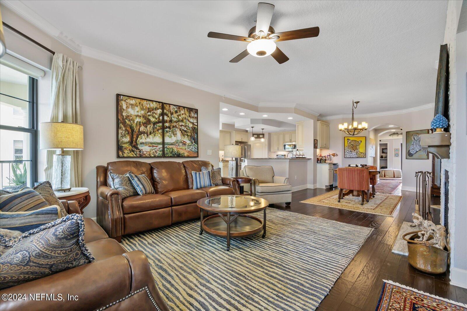 3958 Baymeadows Road, Unit 4501 Jacksonville, FL 32217 - Photo 18 of 57 a living room with furniture a chandelier and a flat screen tv