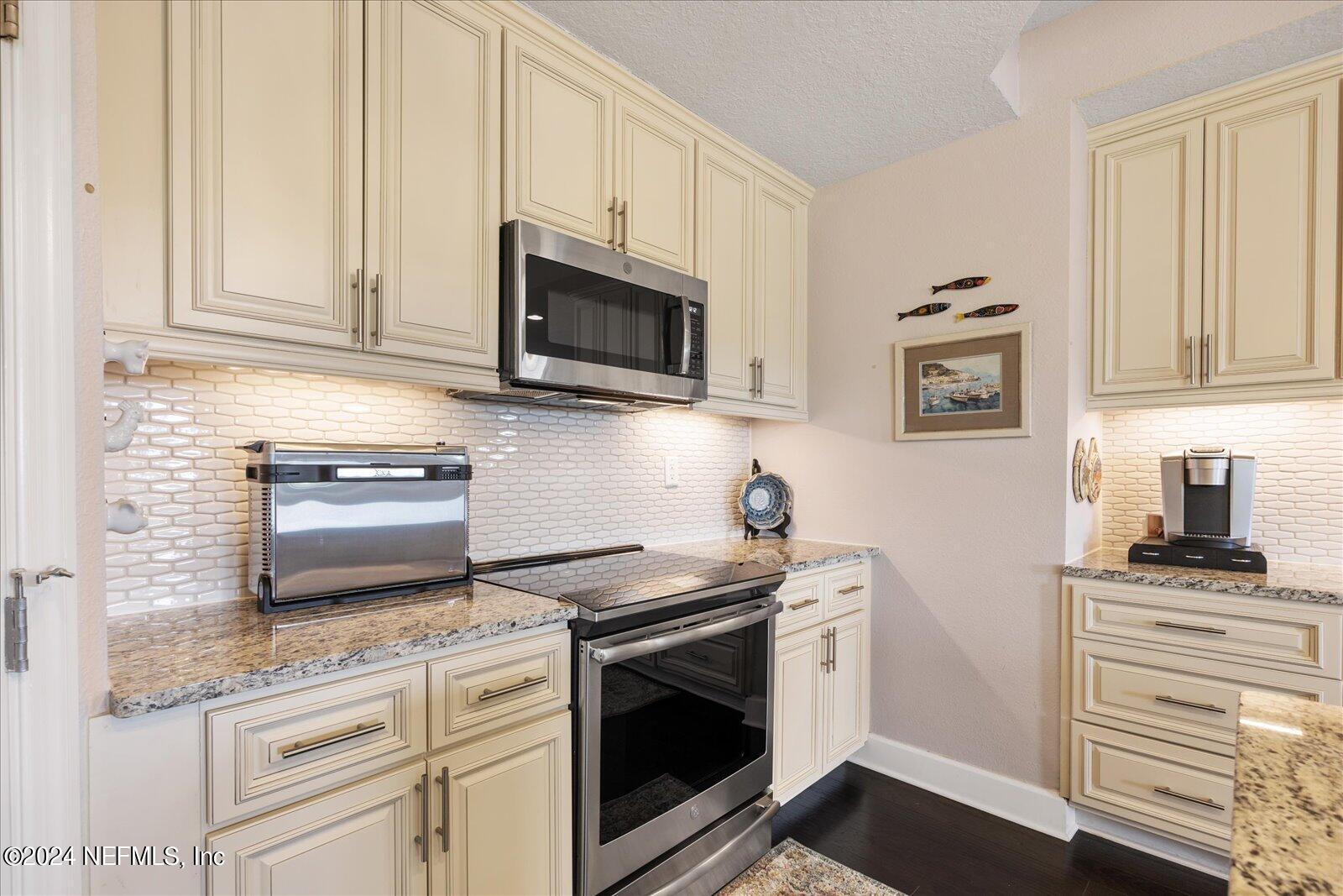 3958 Baymeadows Road, Unit 4501 Jacksonville, FL 32217 - Photo 22 of 57 a kitchen with granite countertop white cabinets and appliances