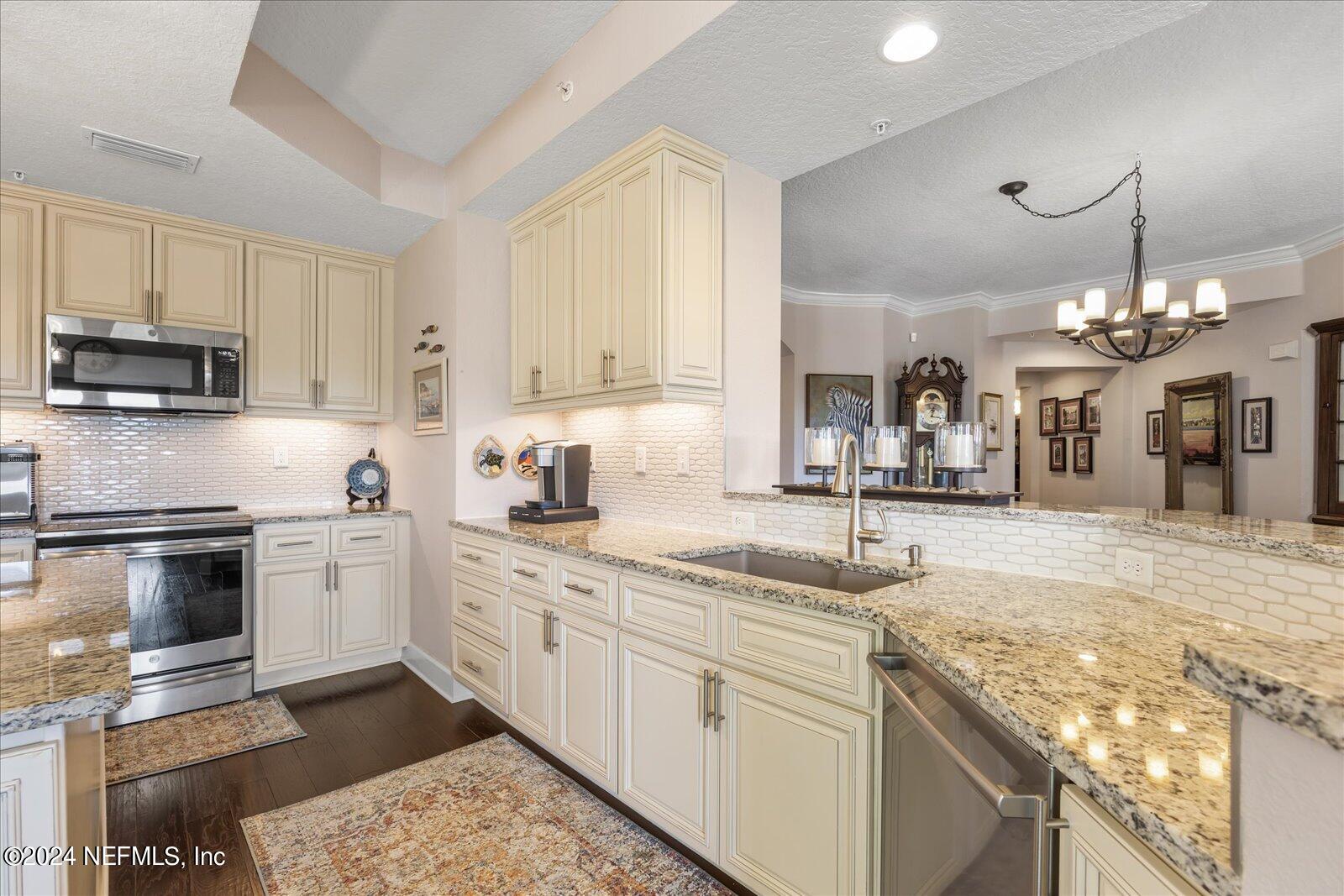 3958 Baymeadows Road, Unit 4501 Jacksonville, FL 32217 - Photo 25 of 57 a kitchen with a sink stove and cabinets