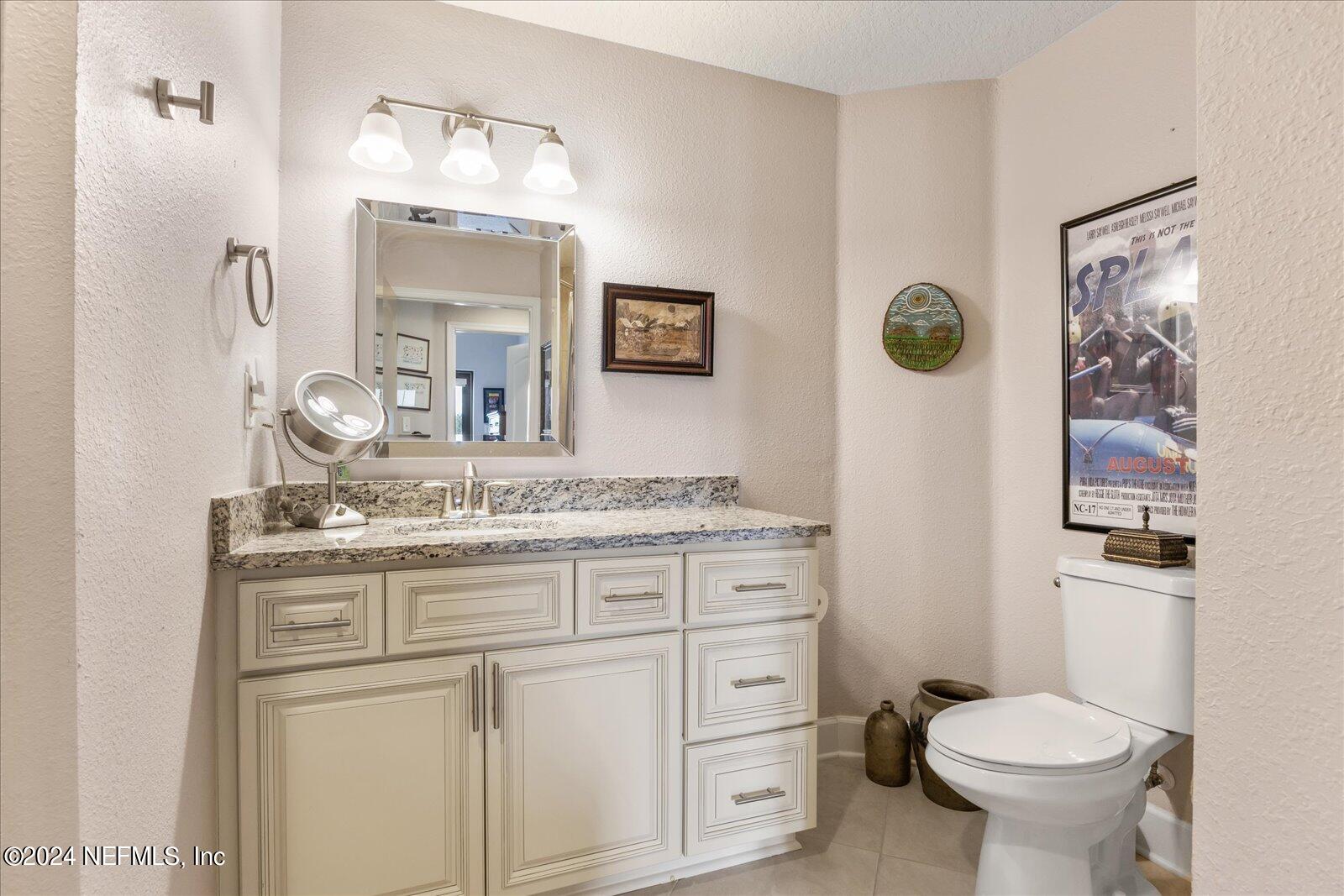 3958 Baymeadows Road, Unit 4501 Jacksonville, FL 32217 - Photo 51 of 57 a bathroom with a granite countertop toilet sink and mirror