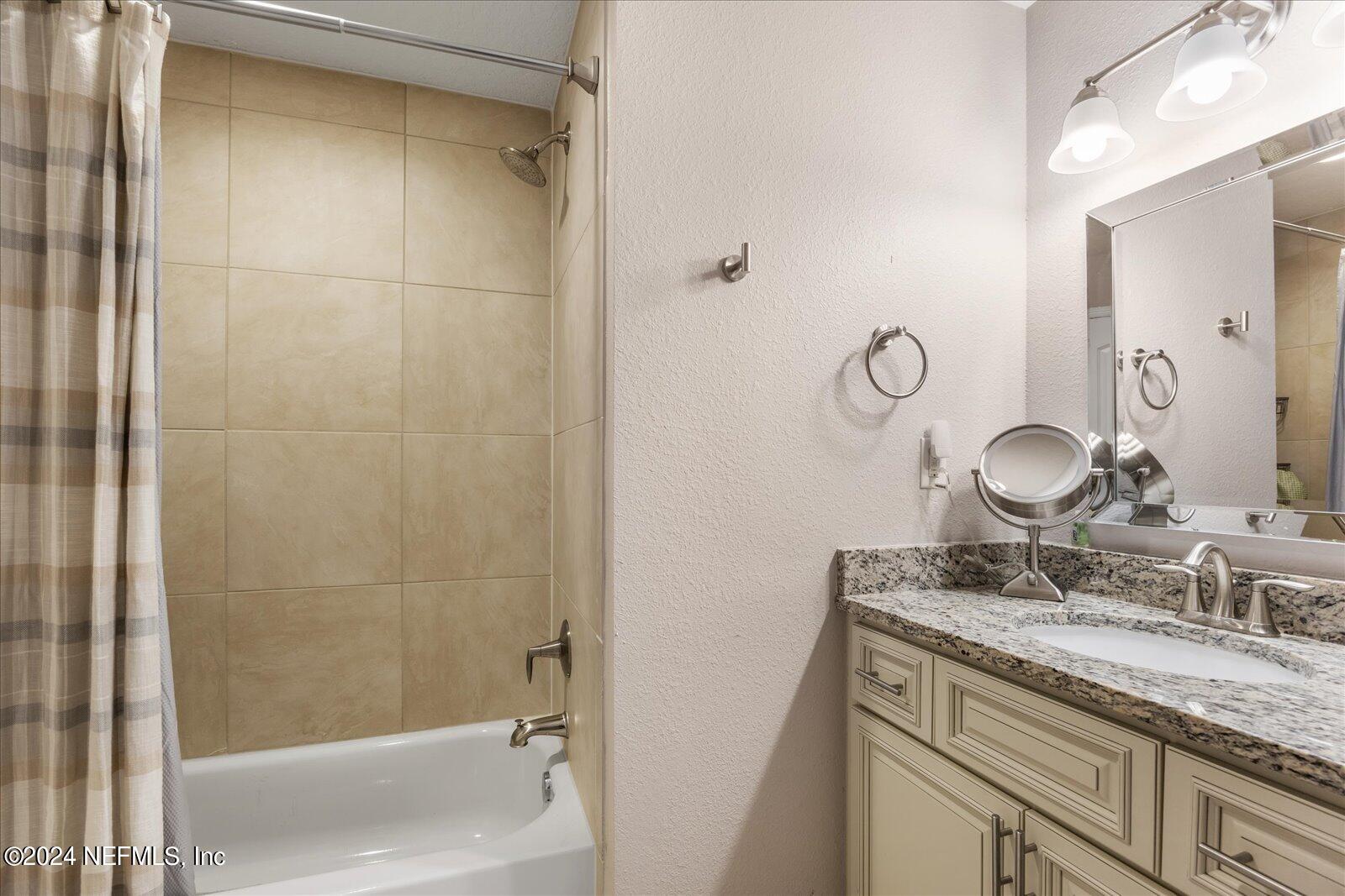 3958 Baymeadows Road, Unit 4501 Jacksonville, FL 32217 - Photo 52 of 57 a bathroom with a granite countertop sink and a mirror