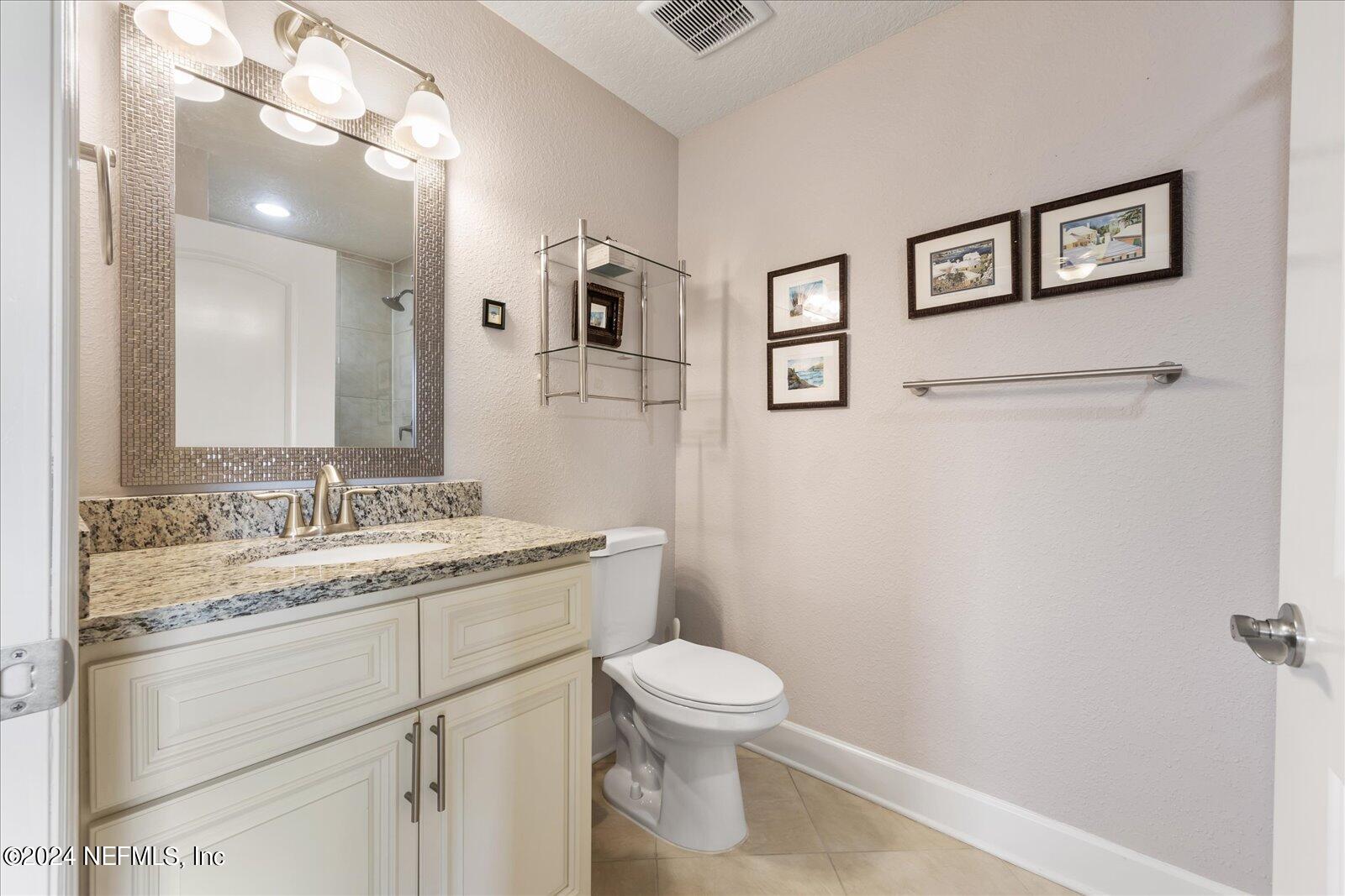 3958 Baymeadows Road, Unit 4501 Jacksonville, FL 32217 - Photo 55 of 57 a bathroom with a granite countertop toilet sink and a mirror