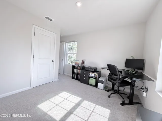 a view of a workspace with furniture and a window