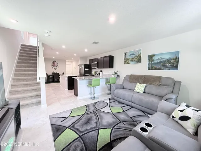 a living room with furniture kitchen view and a couch