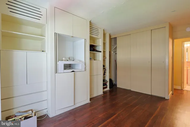 a view of a hallway with wooden floor and closet area
