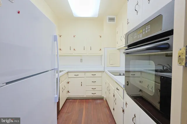 a kitchen with white cabinets and white appliances