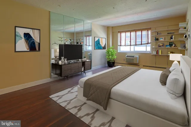 a bedroom with a balcony a bed wooden floor and window